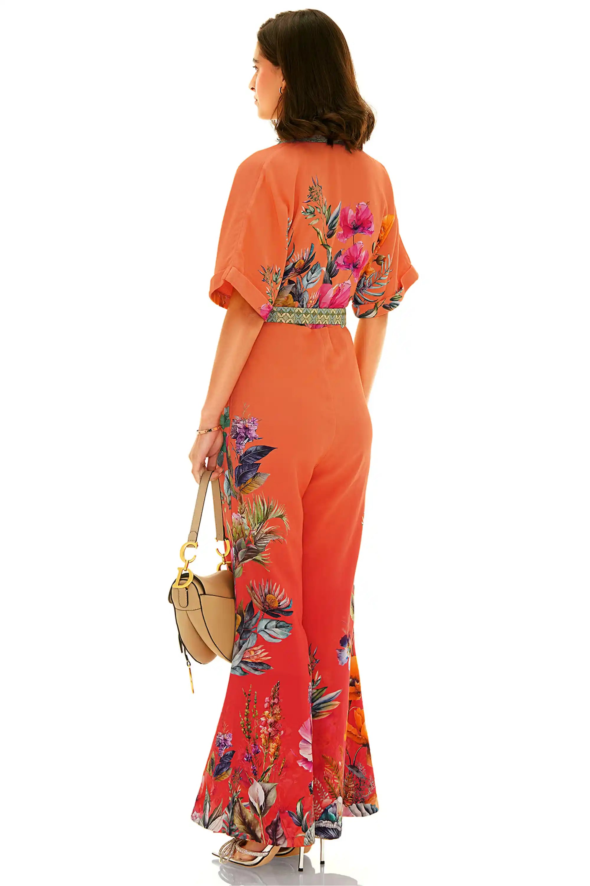 Back view of orange floral wide-leg jumpsuit featuring bold floral design
