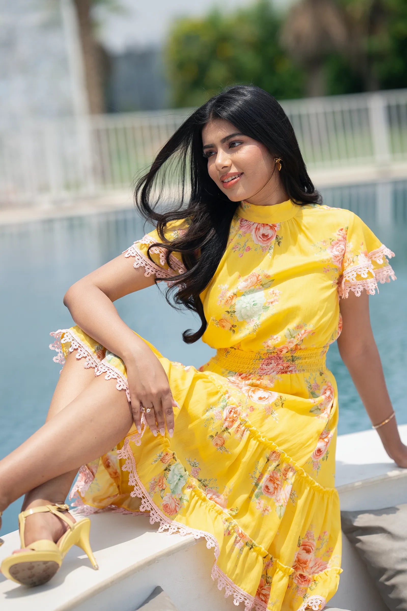 Indian woman in yellow floral cotton midi dress at the pool, luxury resort fashion trend, Summer 2025.