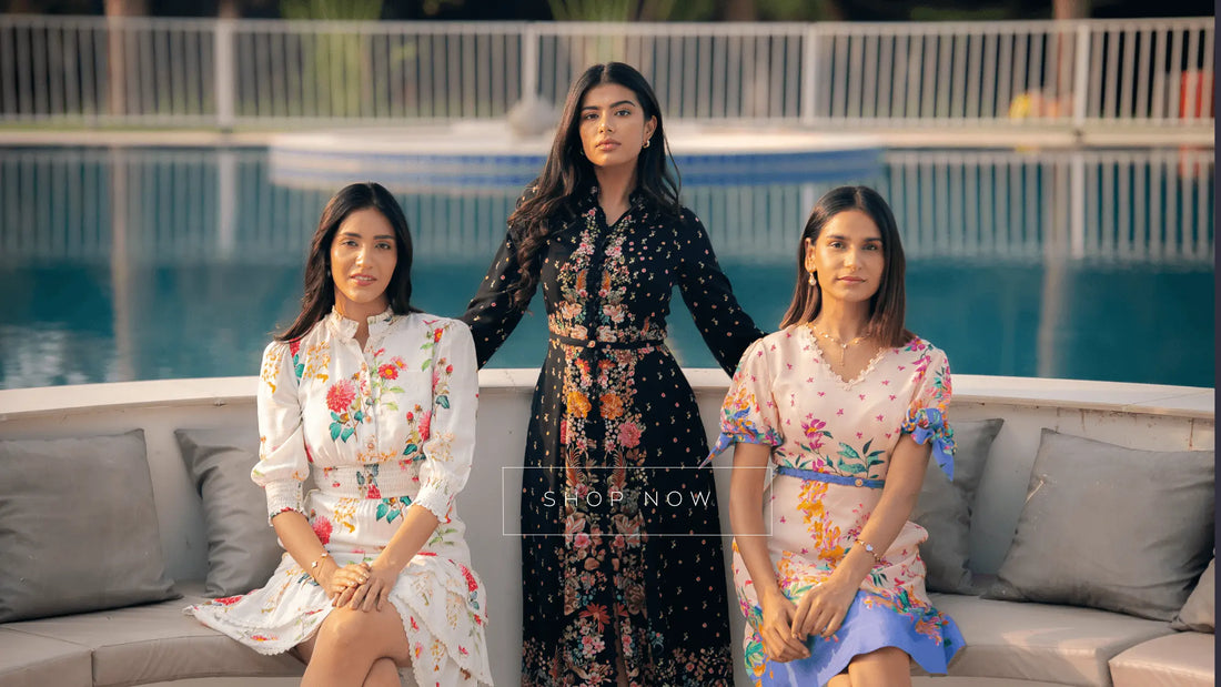 Three women wearing Pretty Pixie floral dresses sitting by a poolside