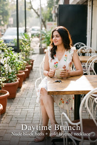 Woman in Pretty Pixie ivory botanical floral tiered sleeveless mini dress styled for a styled look