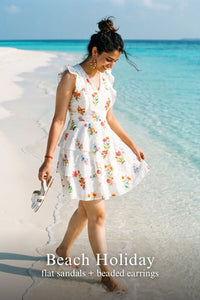 Woman in Pretty Pixie ivory botanical floral tiered sleeveless mini dress styled for a styled look