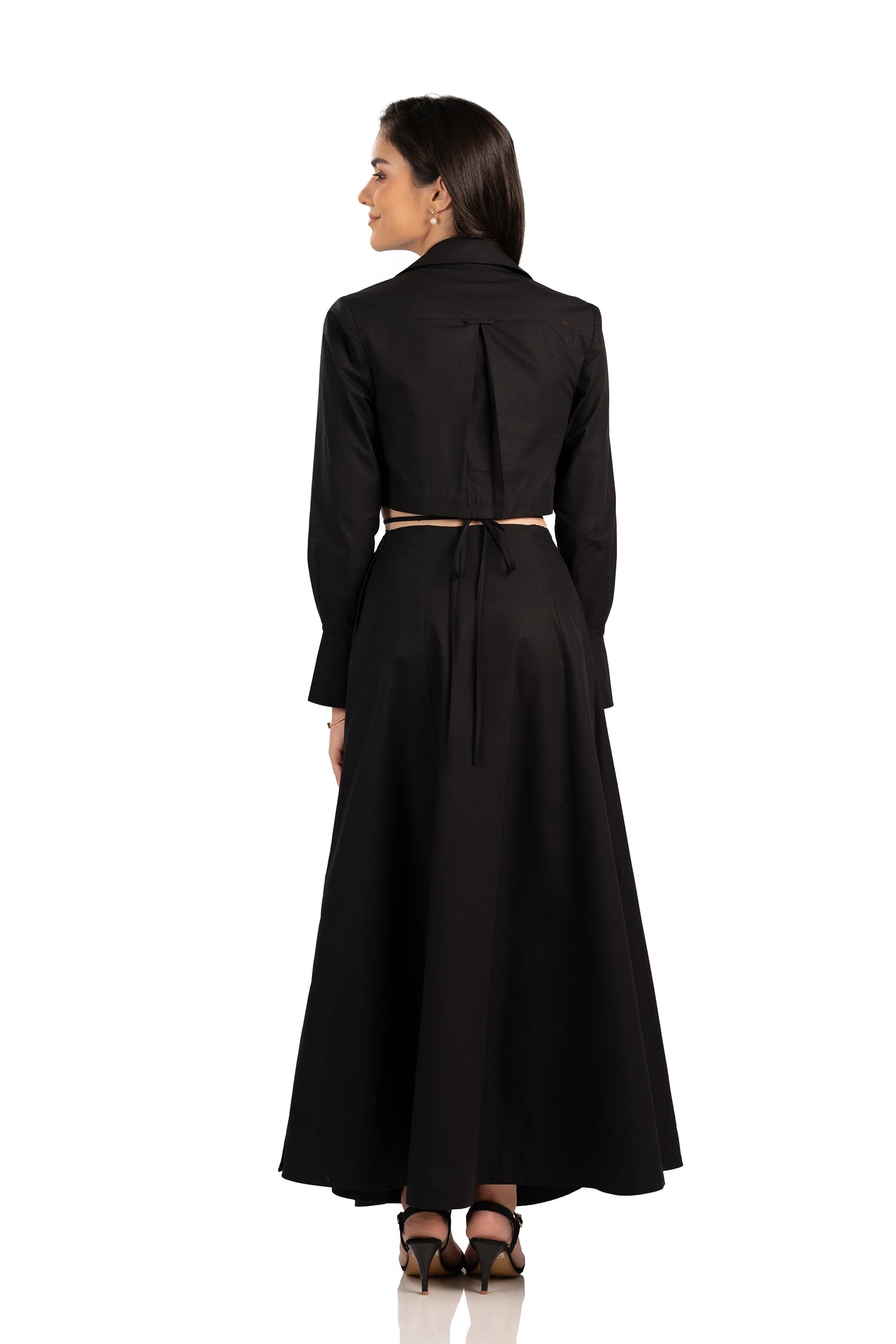 Back view of black maxi dress with tie-back waist, long sleeves, and flowing skirt.