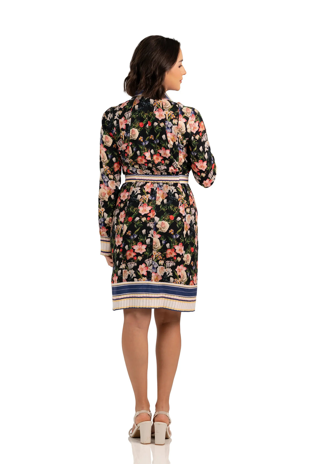 Back view of floral belted shirt dress with multicolor print, long sleeves, and striped hemline.
