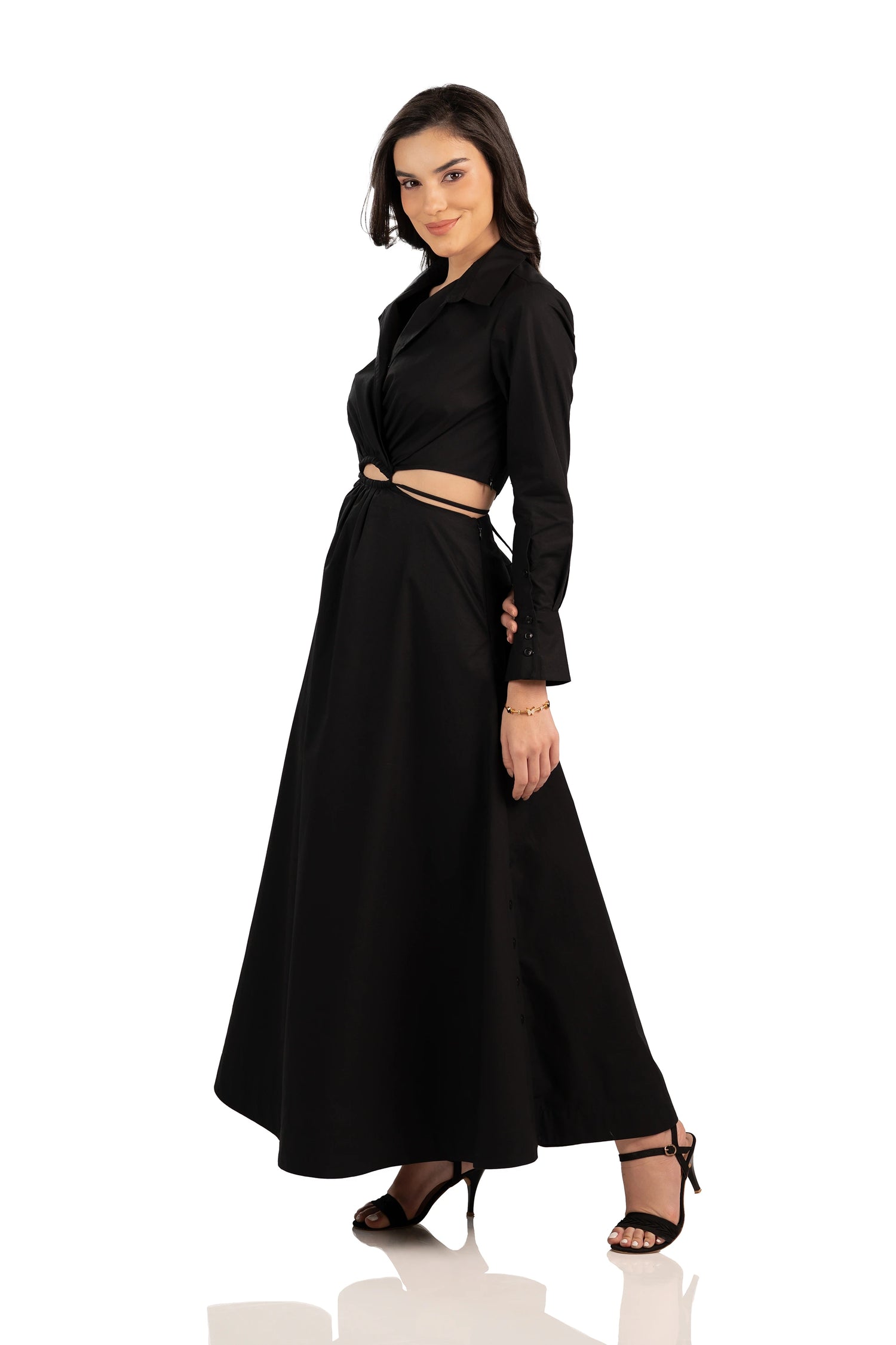 Side profile of black cutout maxi dress with long sleeves, collared neckline, and flared hem.