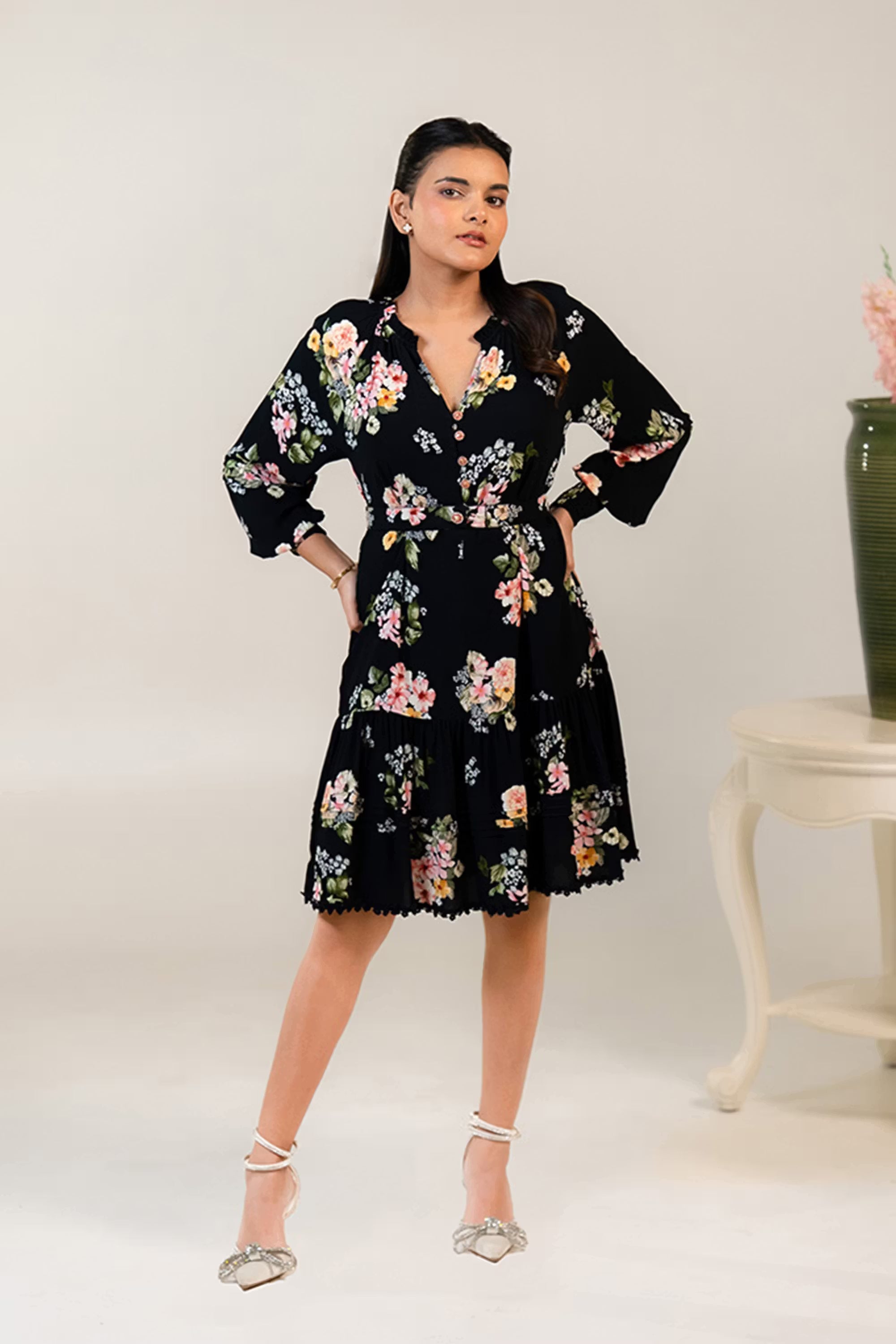 Front view of black floral short dress with button-down detail, waist belt and long sleeves