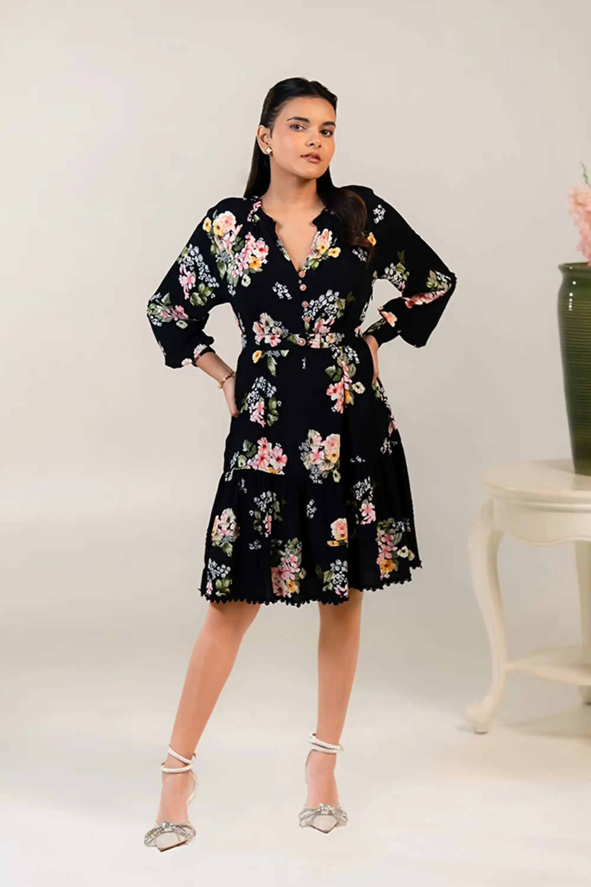 Closeup of black floral mini dress showing colorful floral pattern and waist belt.