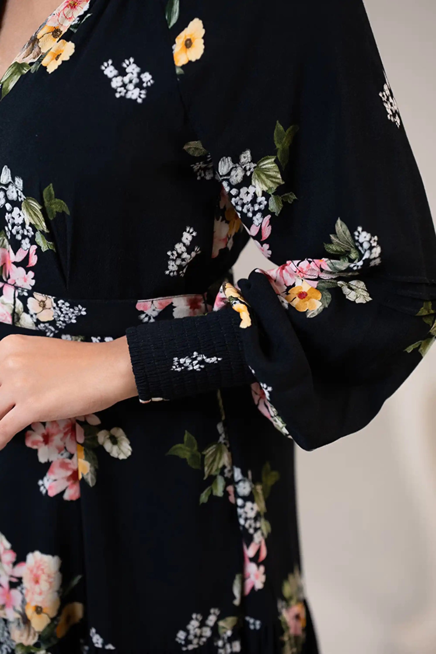Sleeve detail of black floral belted mini dress with gathered cuff design.