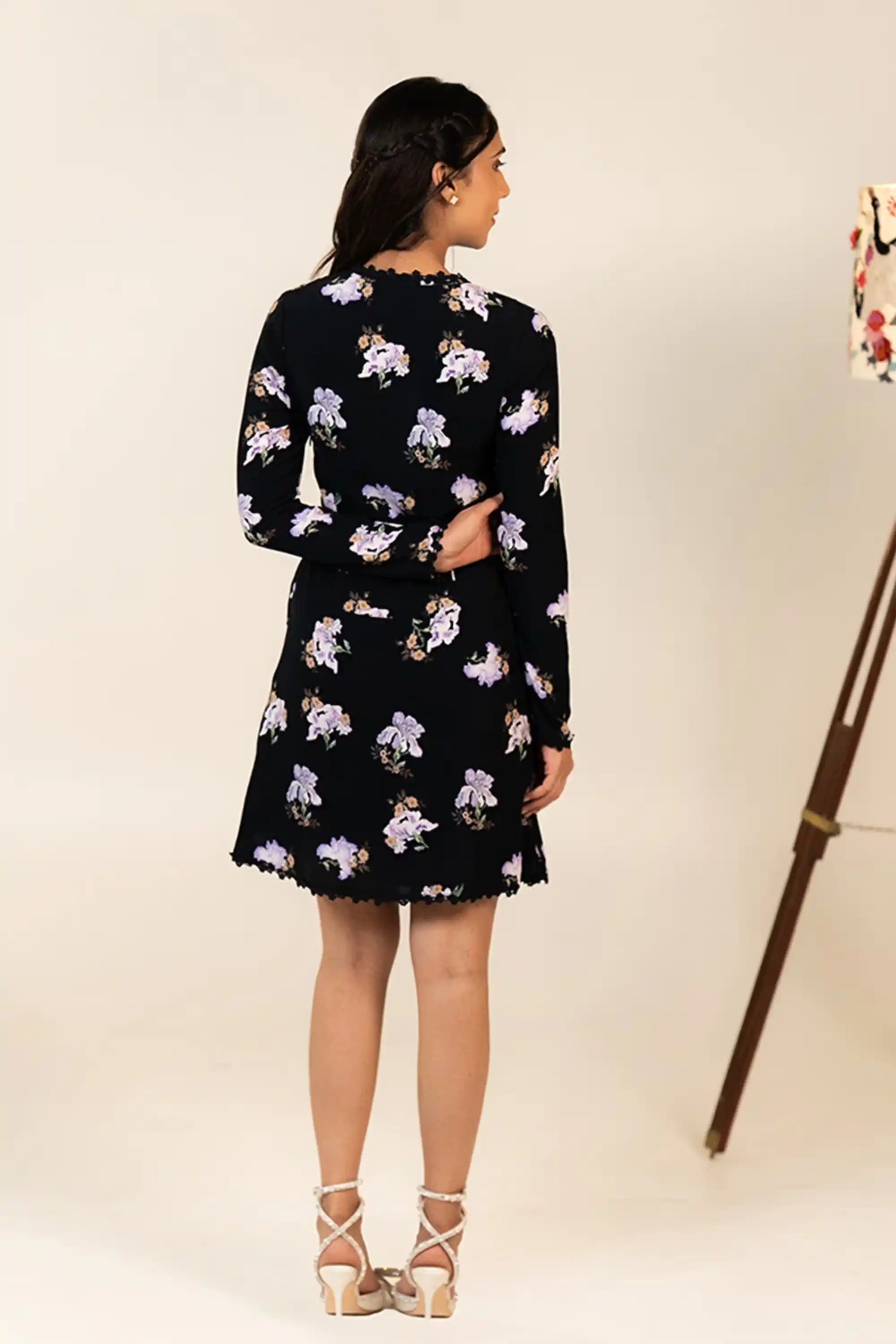 Back view of black mini dress with lilac floral pattern and elegant detailing