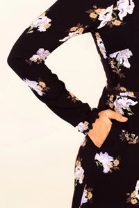 Closeup of sleeve and pocket detail on black floral mini dress with lilac prints