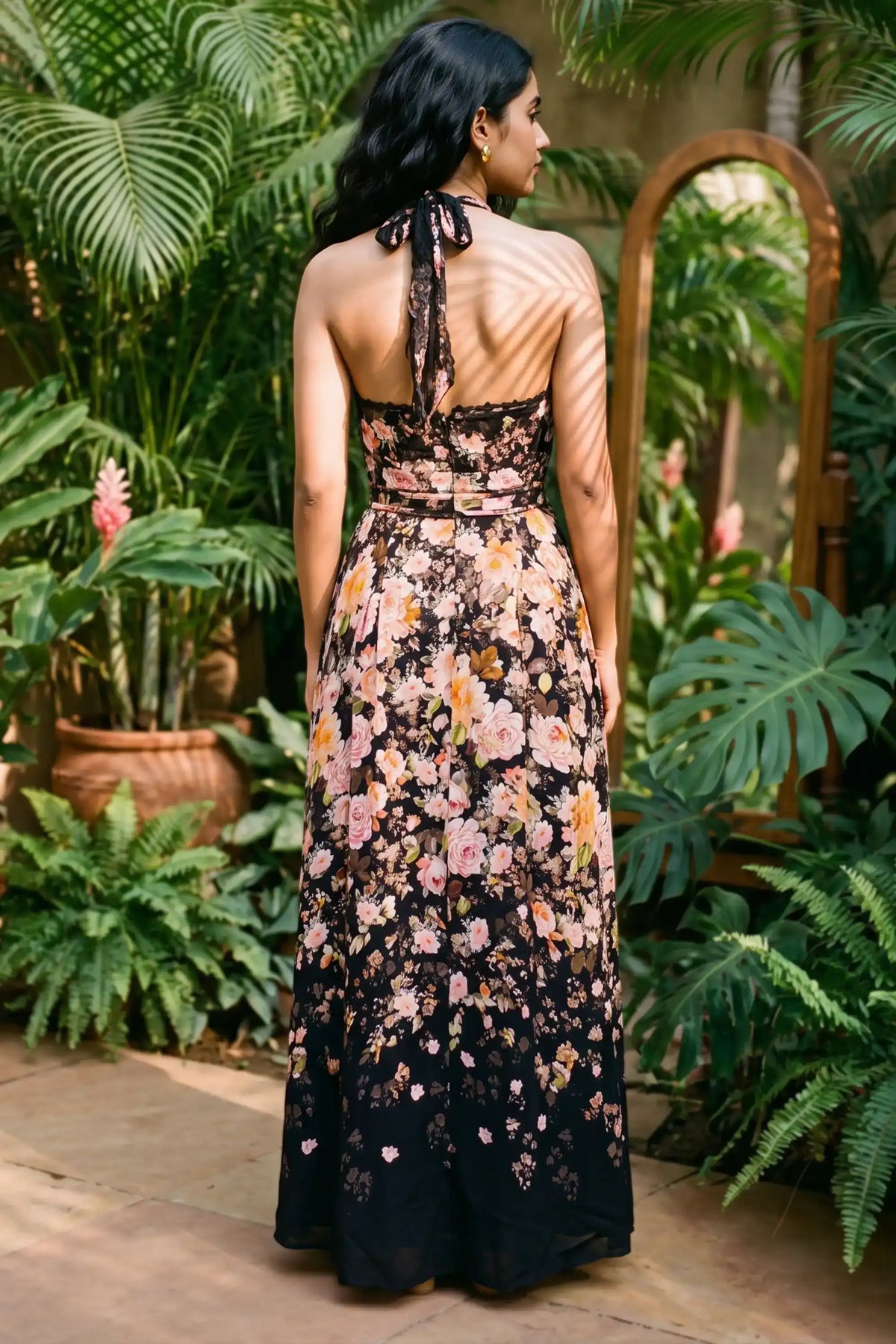 Back view of black floral maxi dress with open back and halter tie detail; organic cotton women's evening occasion dress