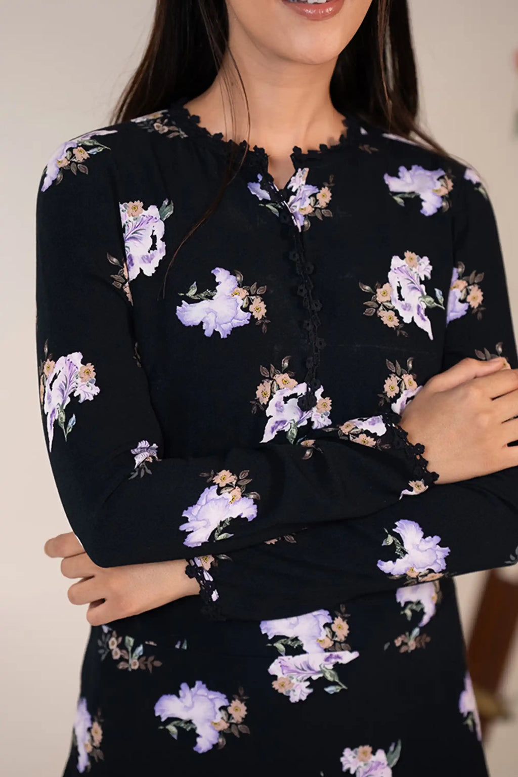 Bodice detail closeup of black mini dress with lilac floral prints and scalloped neckline