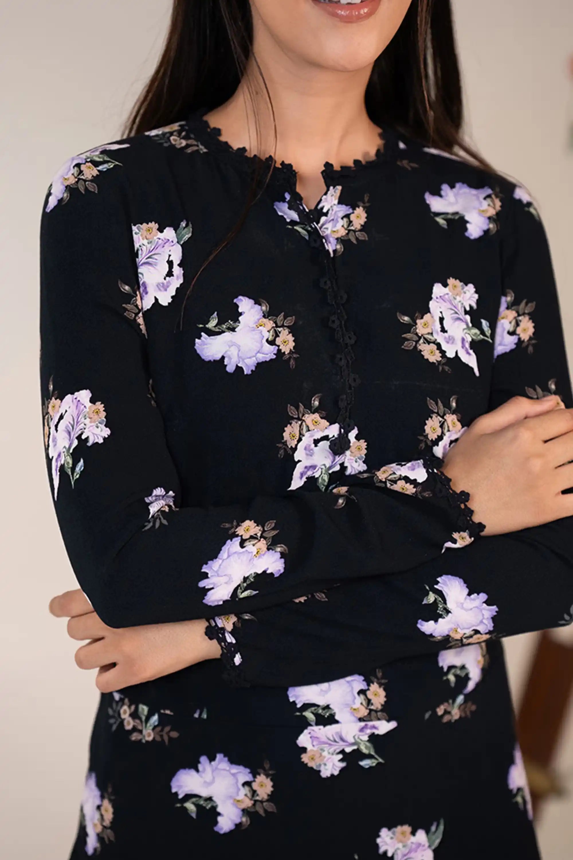 Bodice detail closeup of black mini dress with lilac floral prints and scalloped neckline