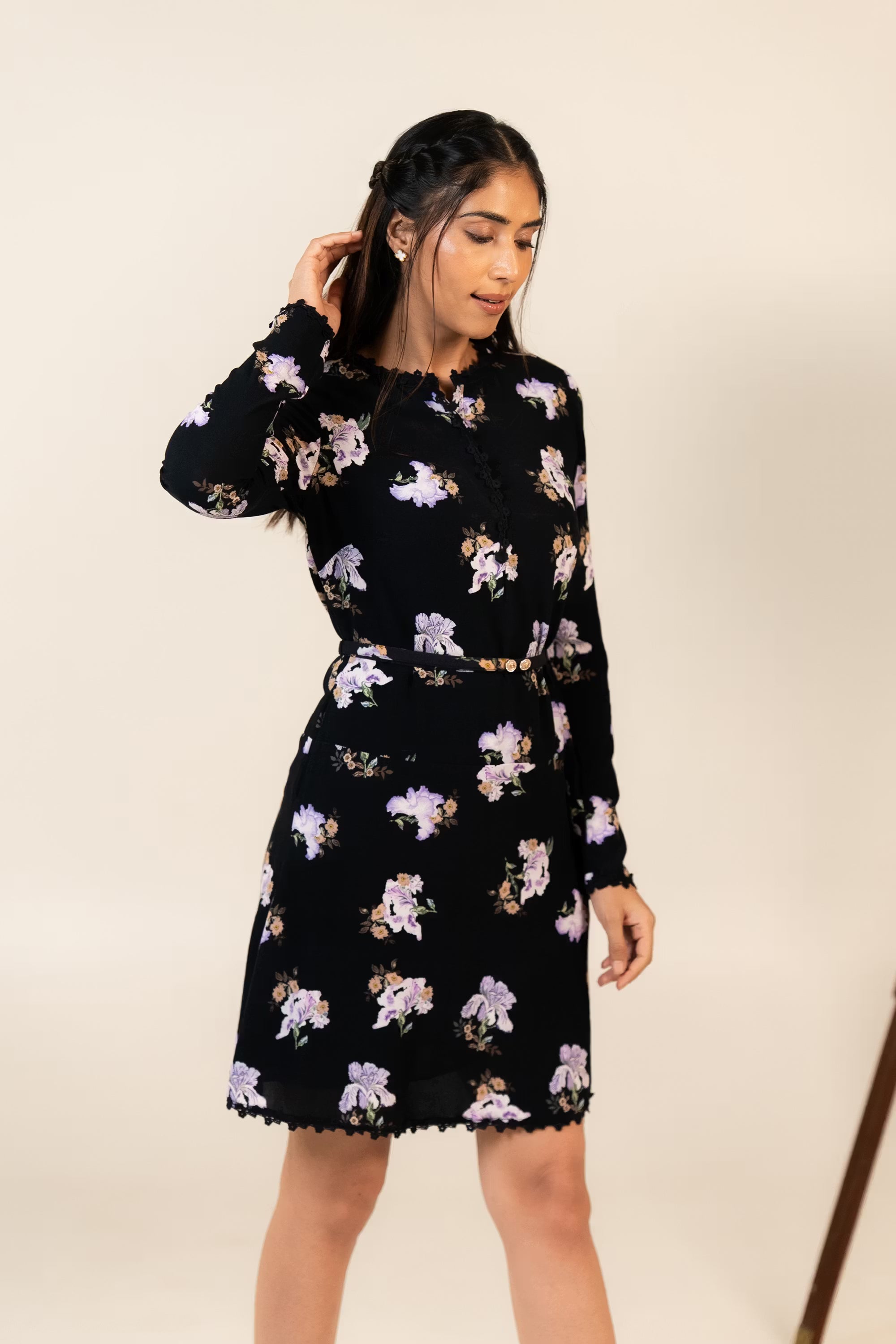 Woman wearing black mini dress with lilac floral print and long sleeves, front pose