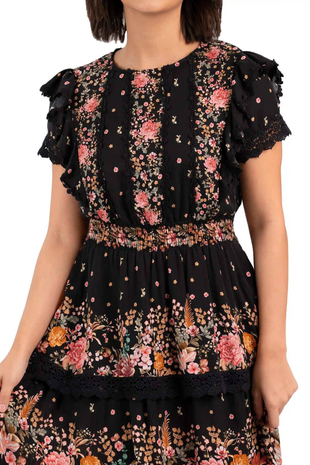 Close-up of bodice showing lace trim and smocked waist on black floral mini dress