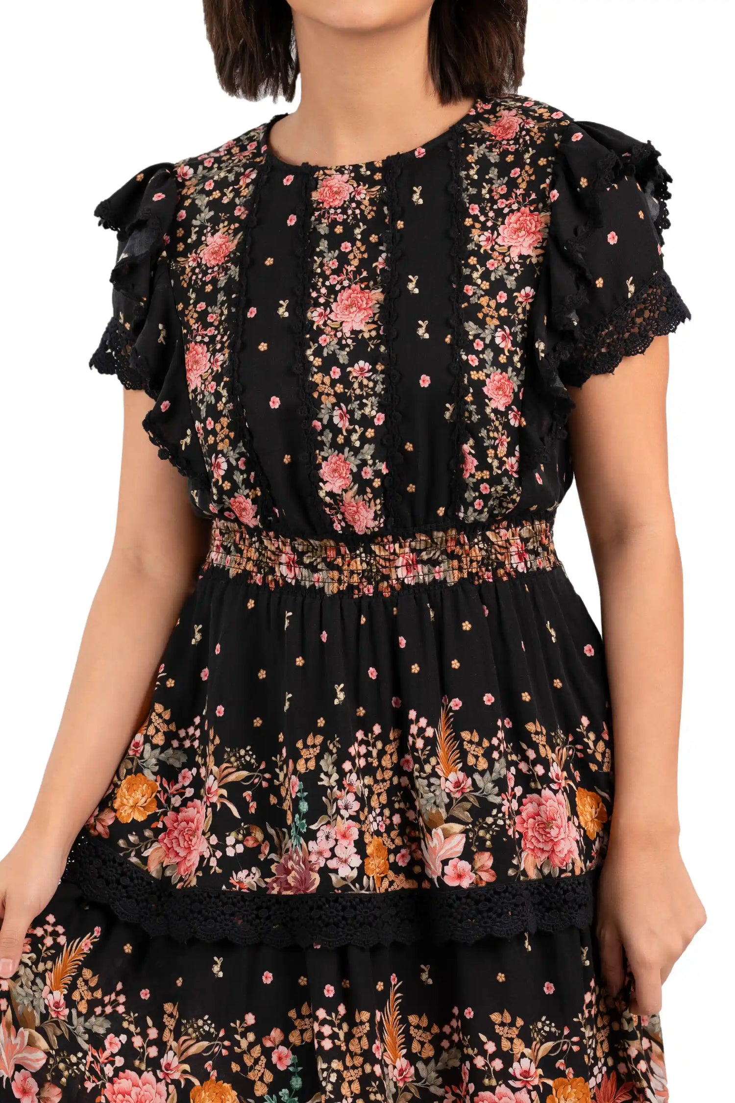 Close-up of bodice showing lace trim and smocked waist on black floral mini dress