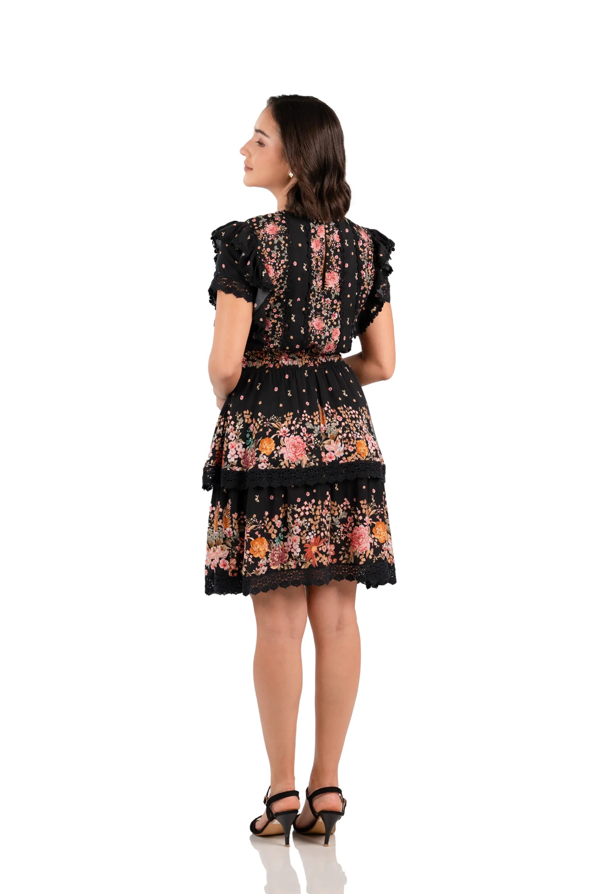 Back view of black floral ruffle mini dress with tiered lace skirt and smocked waist