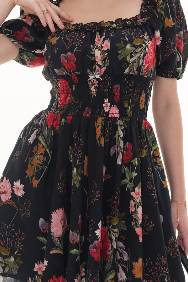 Close-up of Pretty Pixie black floral smocked puff-sleeve mini dress, sleeve detail