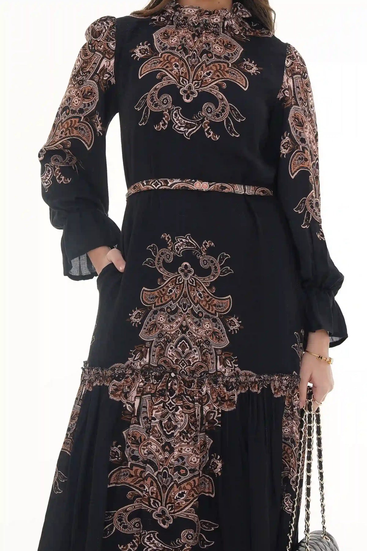 Woman in Pretty Pixie black paisley high-neck tiered belted maxi dress