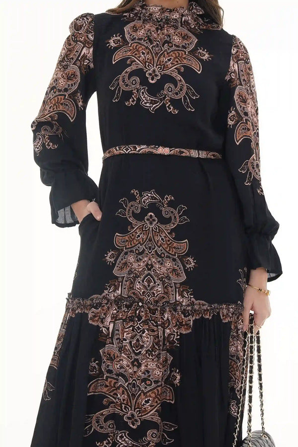 Woman in Pretty Pixie black paisley high-neck tiered belted maxi dress