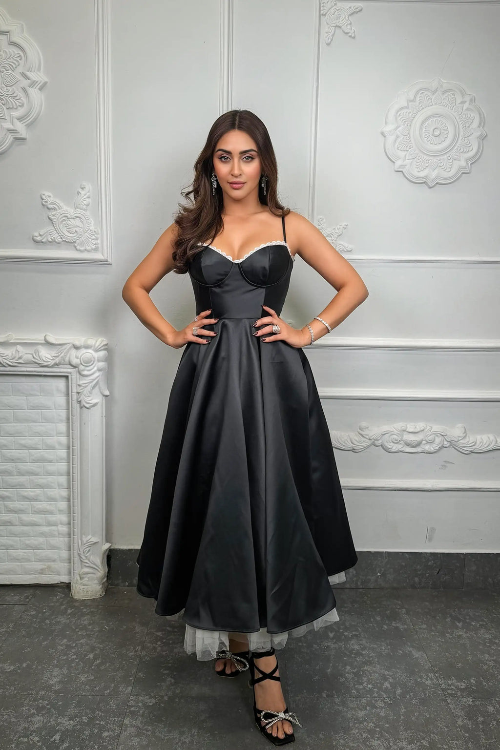 Krystle D'Souza wearing a black satin corset midi dress with lace trim and a flared skirt, styled for an elegant evening or party look by Pretty Pixie.