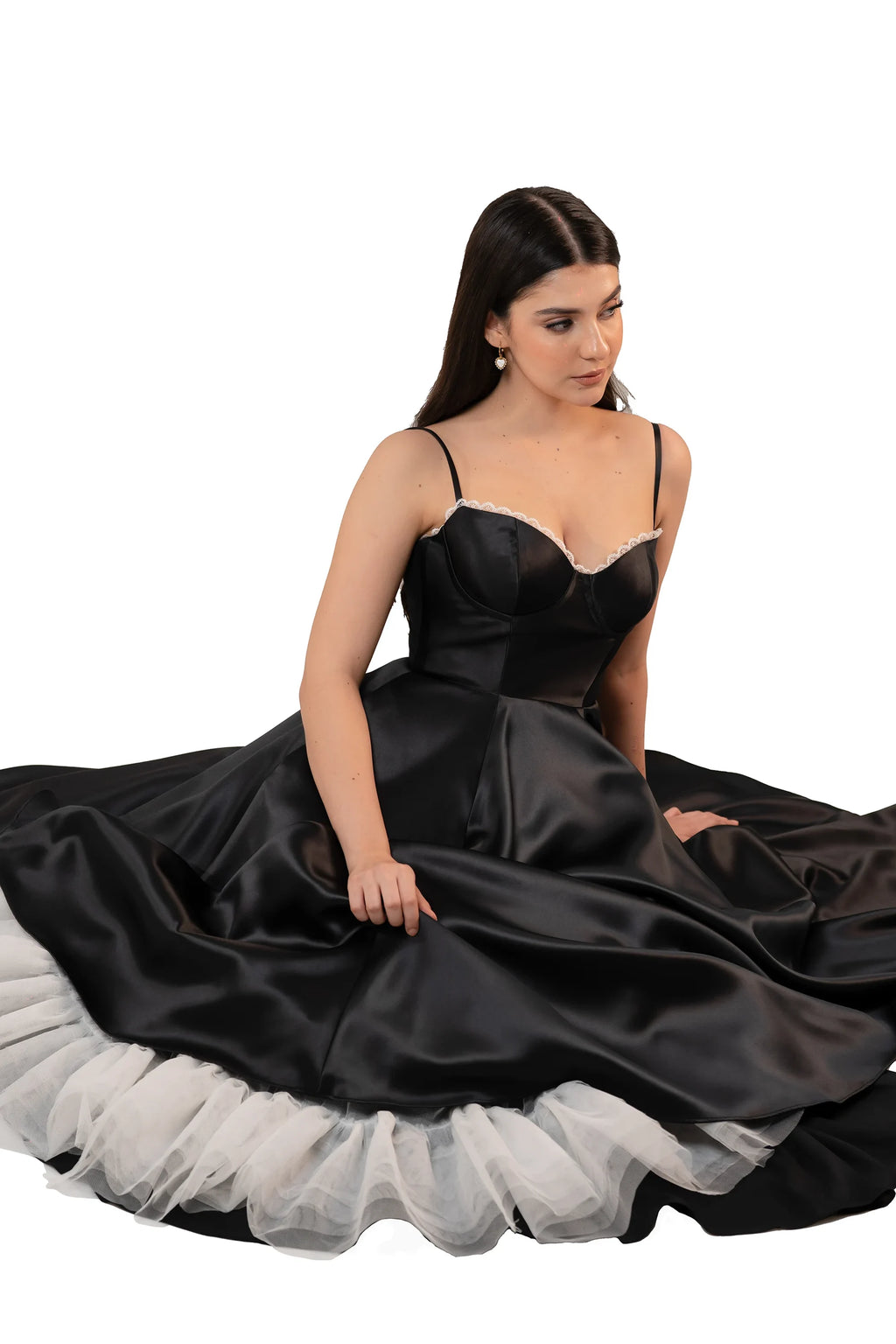 Black satin midi dress with voluminous skirt and white petticoat detail – sitting pose
