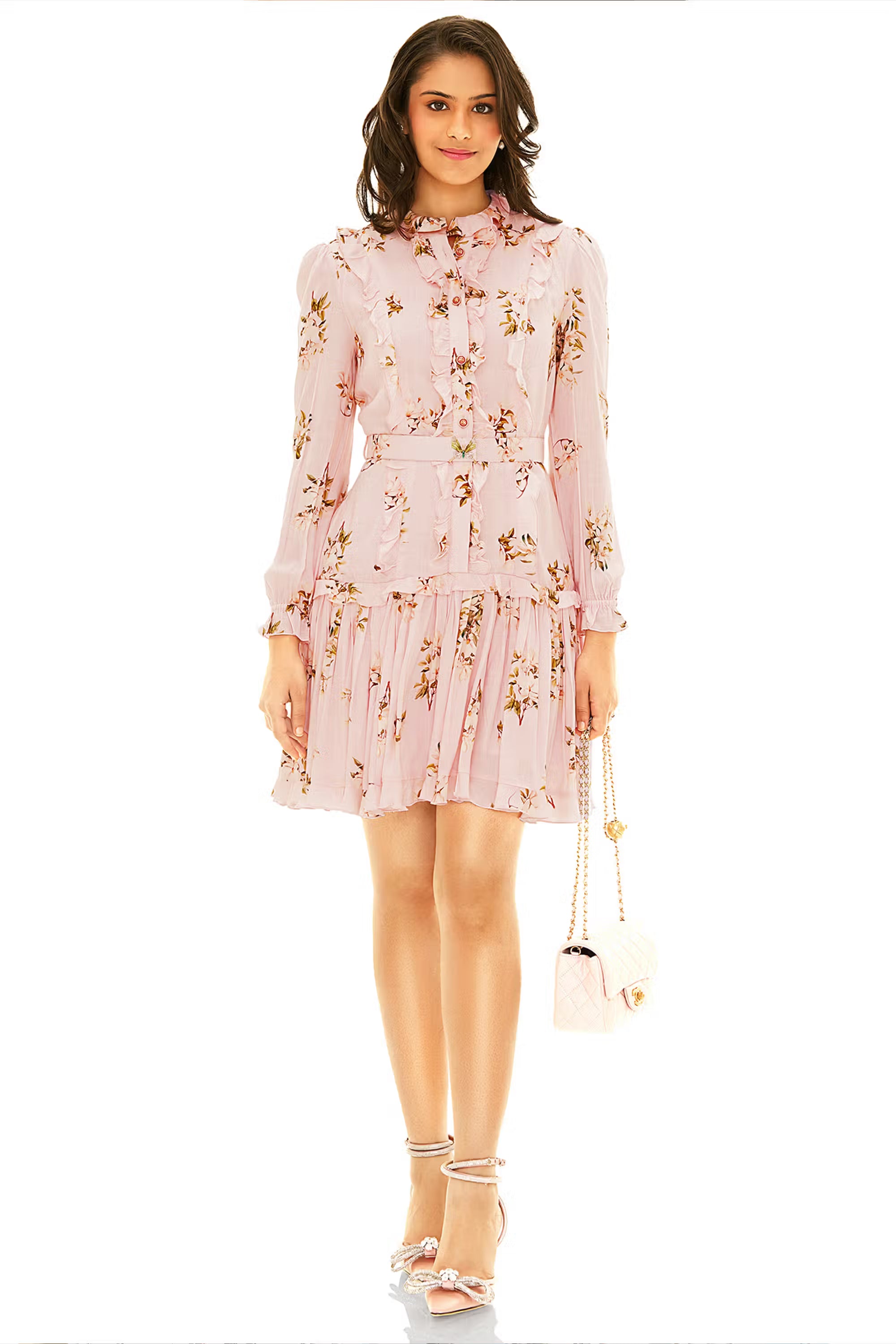 Blush floral long sleeve ruffle mini dress with belt and pleated hem, styled with strappy heels and quilted bag