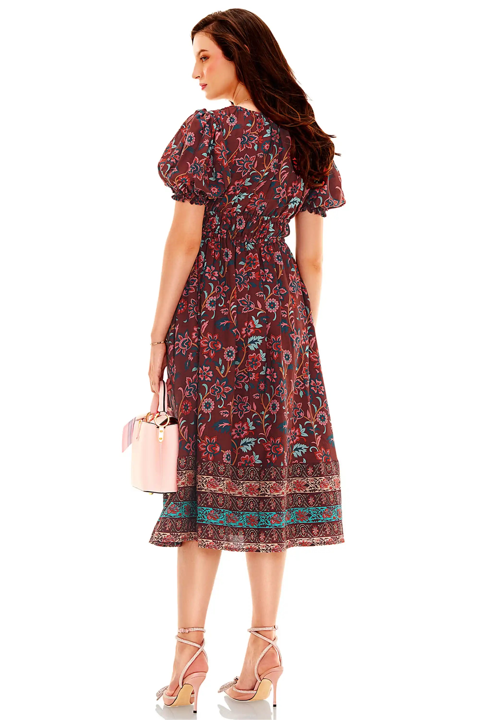 Back view of burgundy floral puff sleeve midi dress with elastic waist and floral border print