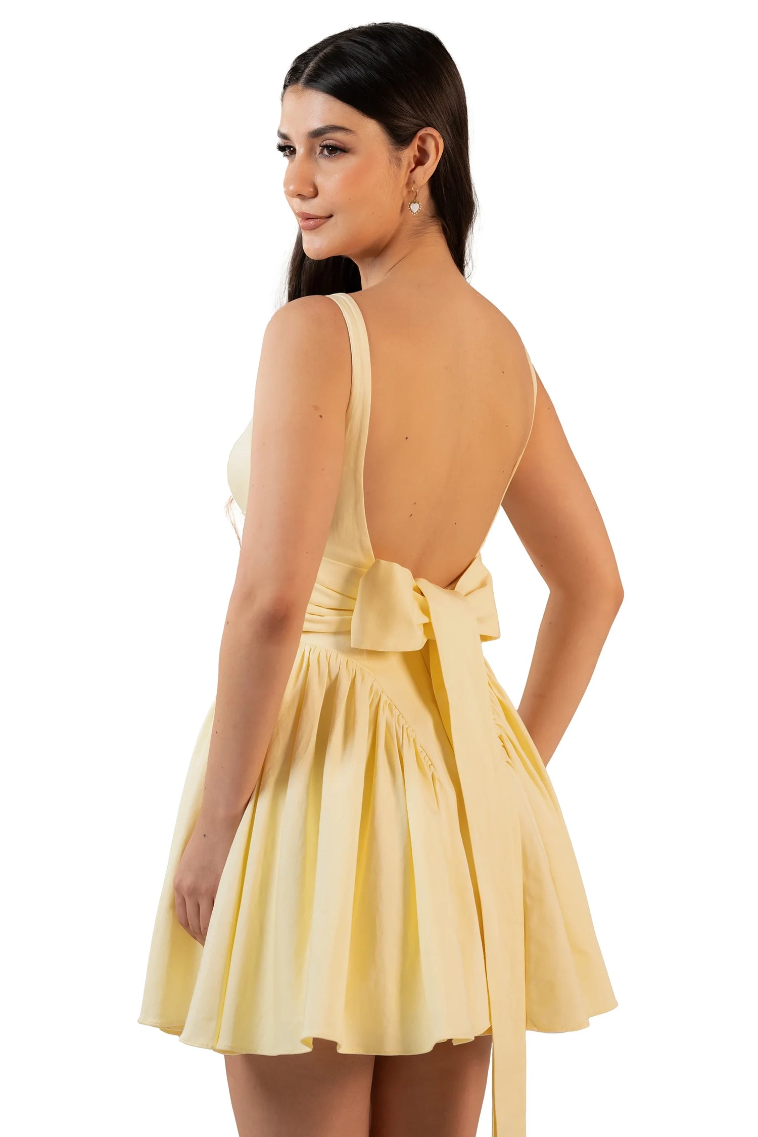 Back angle close-up: low back with long bow, yellow mini dress