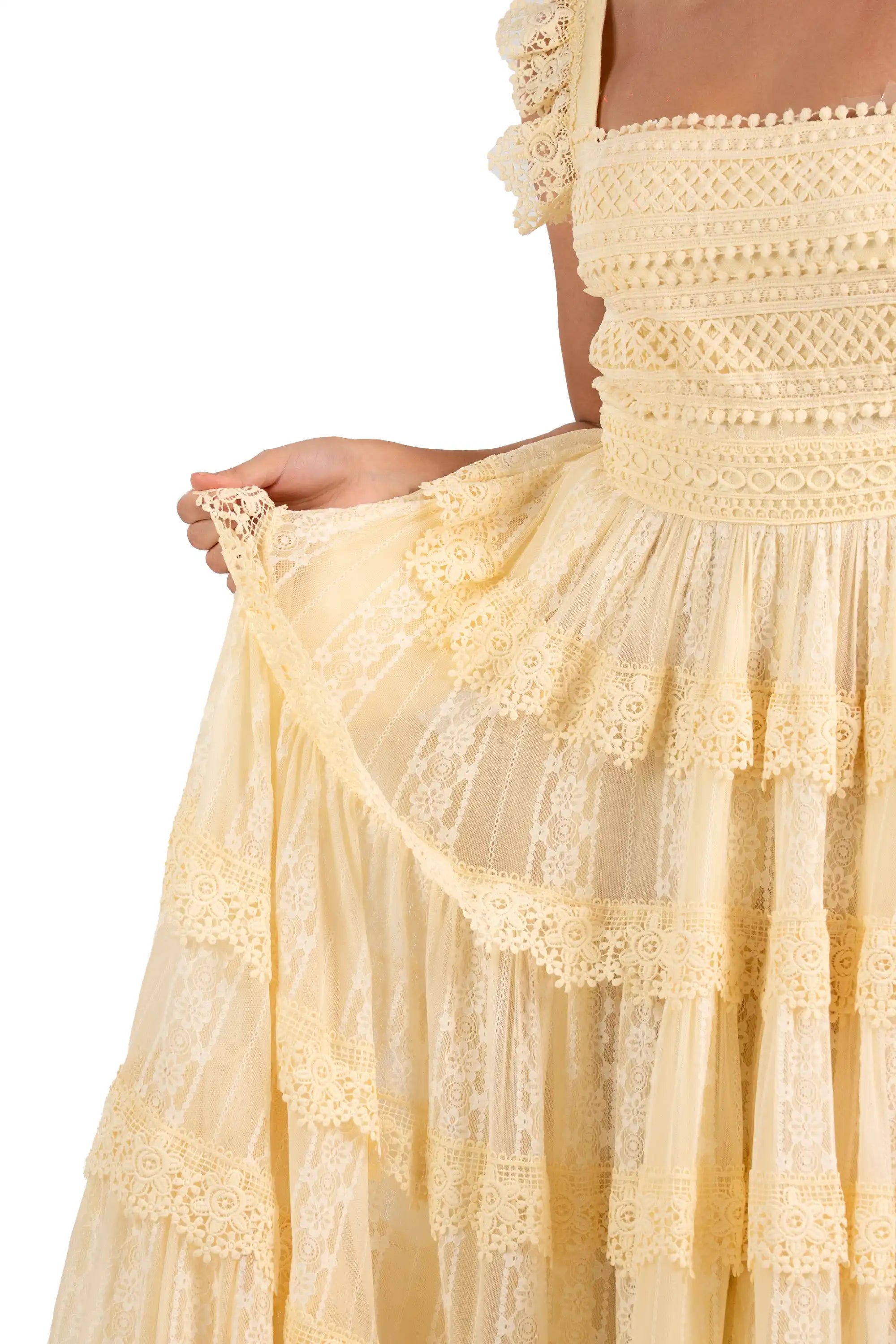 Skirt detail of buttercream lace maxi dress with tiered floral lace layers.
