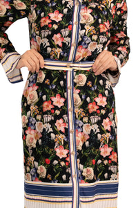 Close-up of black floral belted shirt dress showing button details, waist belt, and striped trim accents.