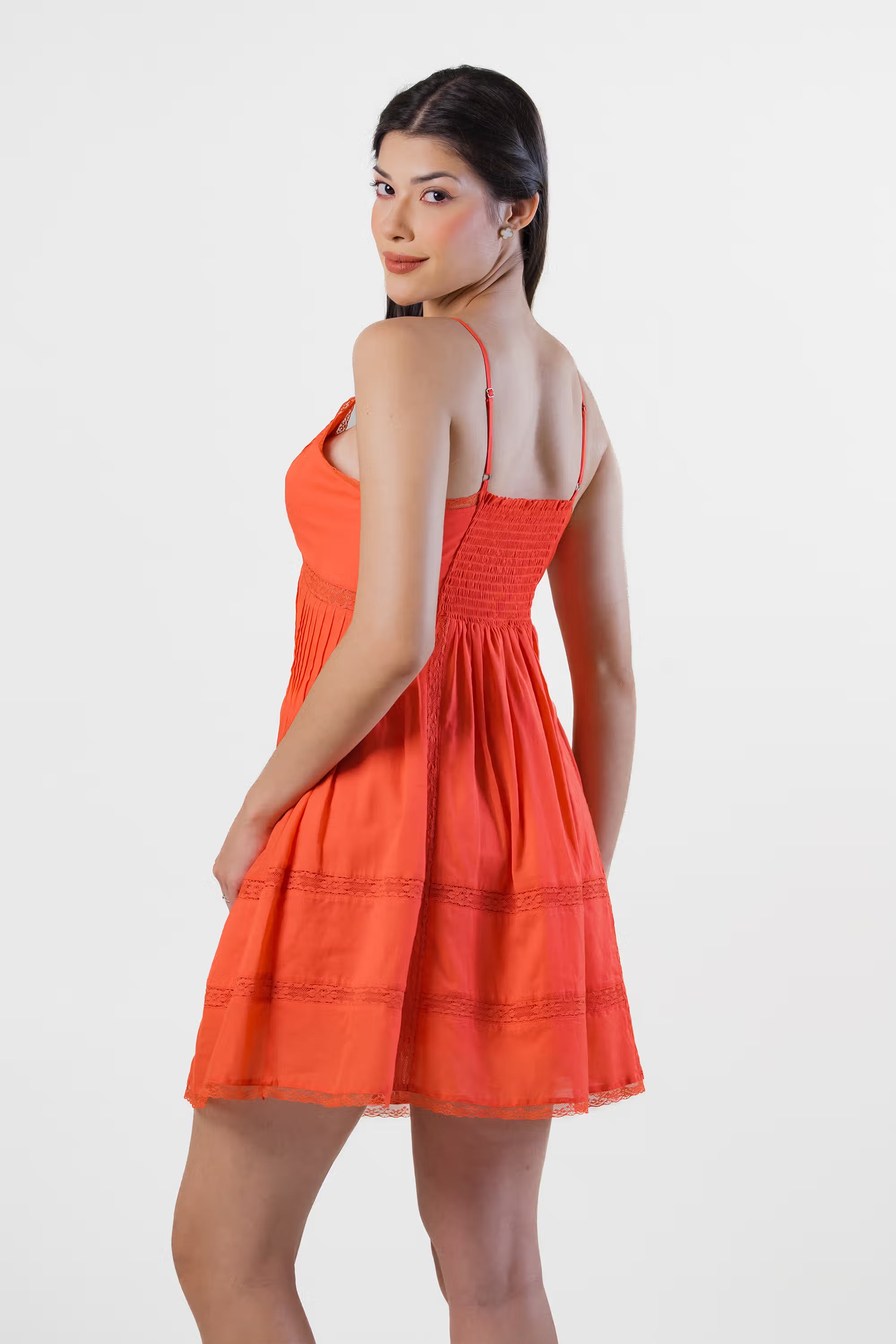 Back view of red-orange mini dress with smocked waist and lace panel details, trendy summer wear