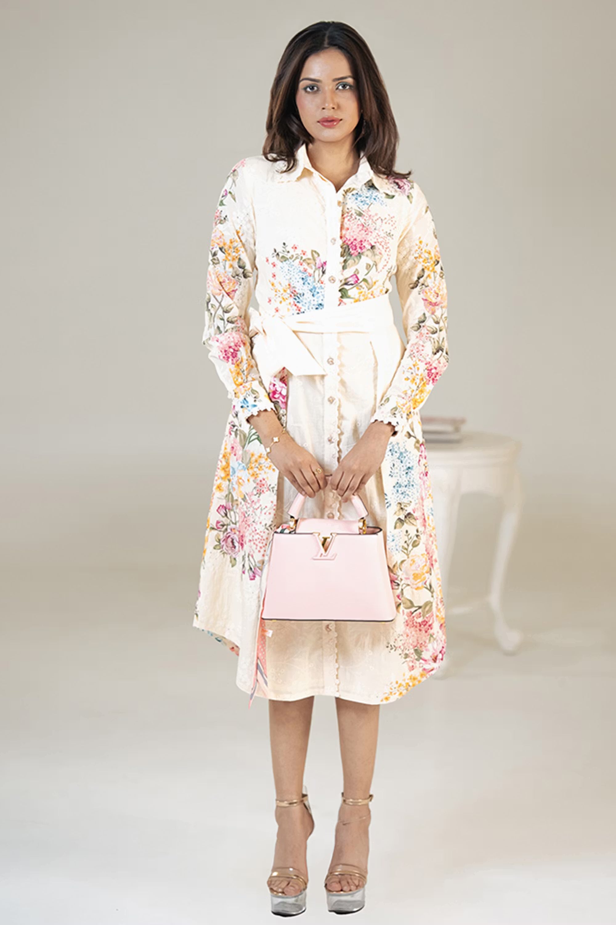 Model wearing cream floral belted shirt dress front view with pink handbag and silver heels