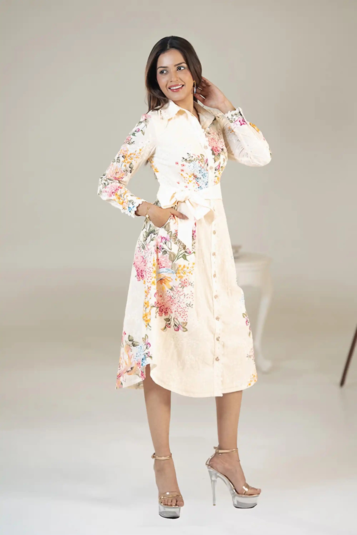 Smiling woman in cream floral belted shirt dress with waist tie and pockets