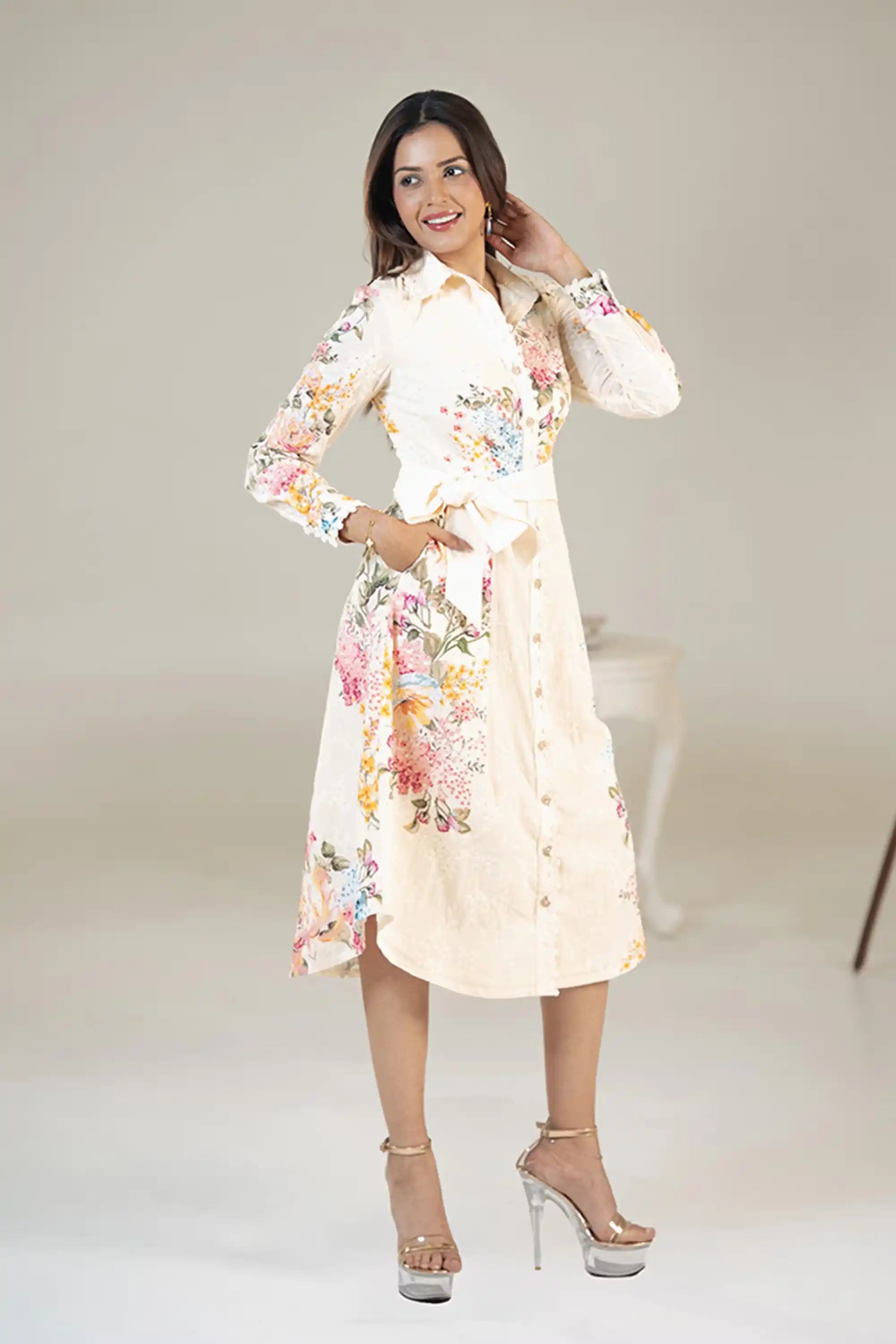 Smiling woman in cream floral belted shirt dress with waist tie and pockets