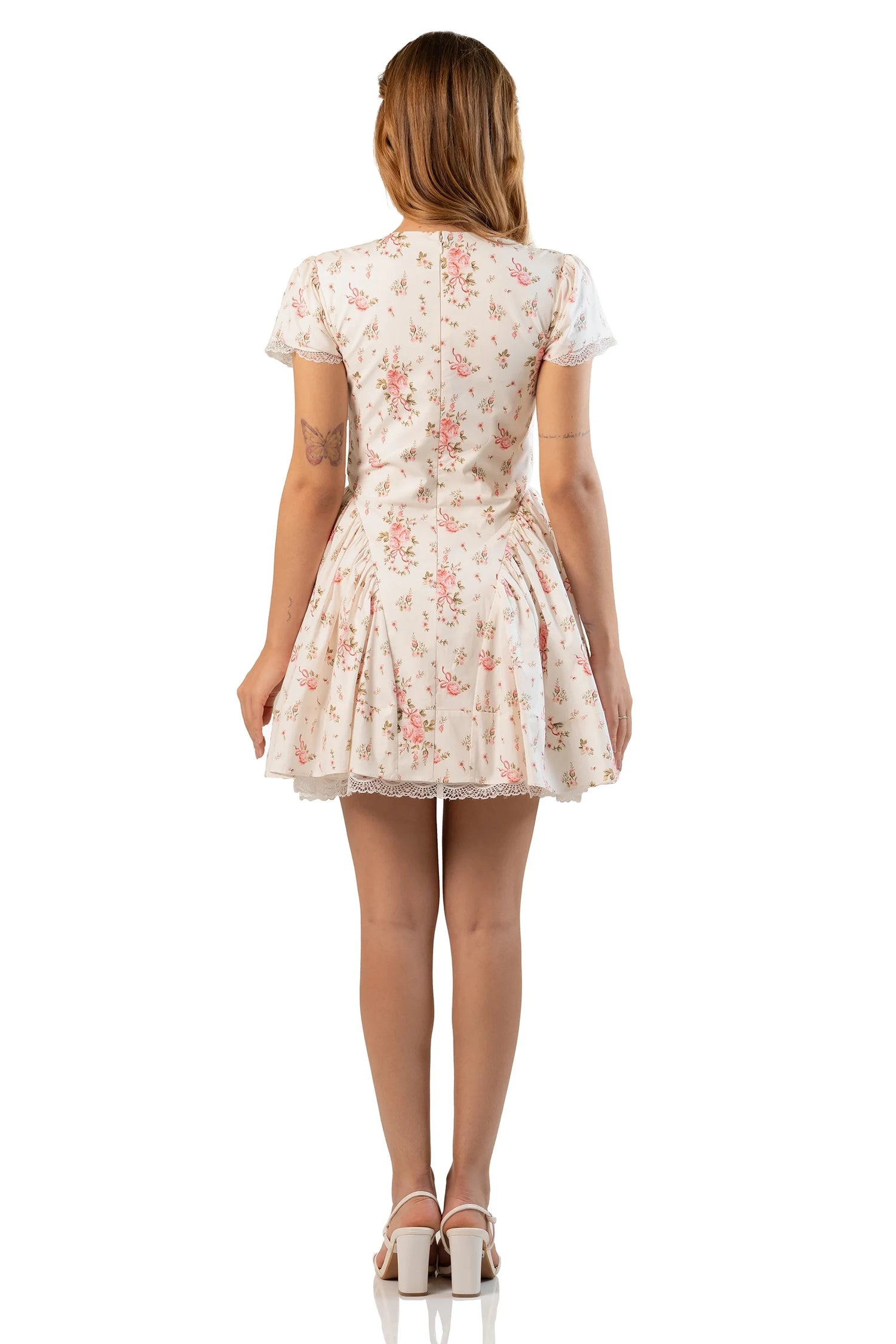 Back view of cream floral mini dress with zip closure and flared skirt.