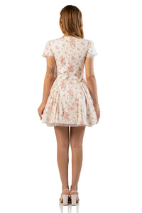 Back view of cream floral mini dress with zip closure and flared skirt.
