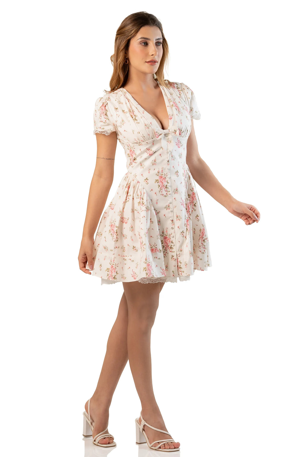 cream floral mini dress with V-neckline and short sleeves, model stands elegantly.