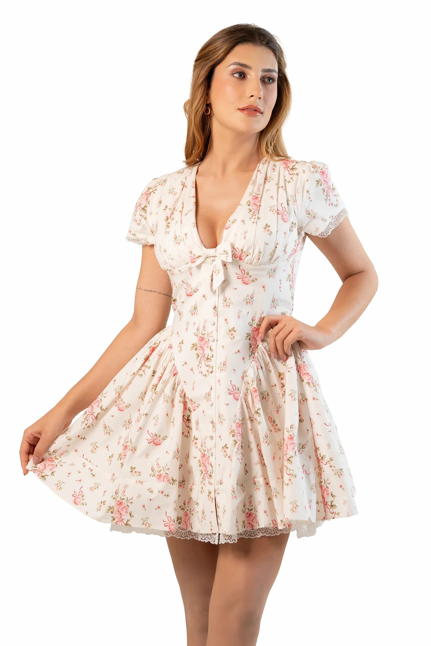 Cream floral mini dress with V-neck and short sleeves as model holds skirt to show flare.
