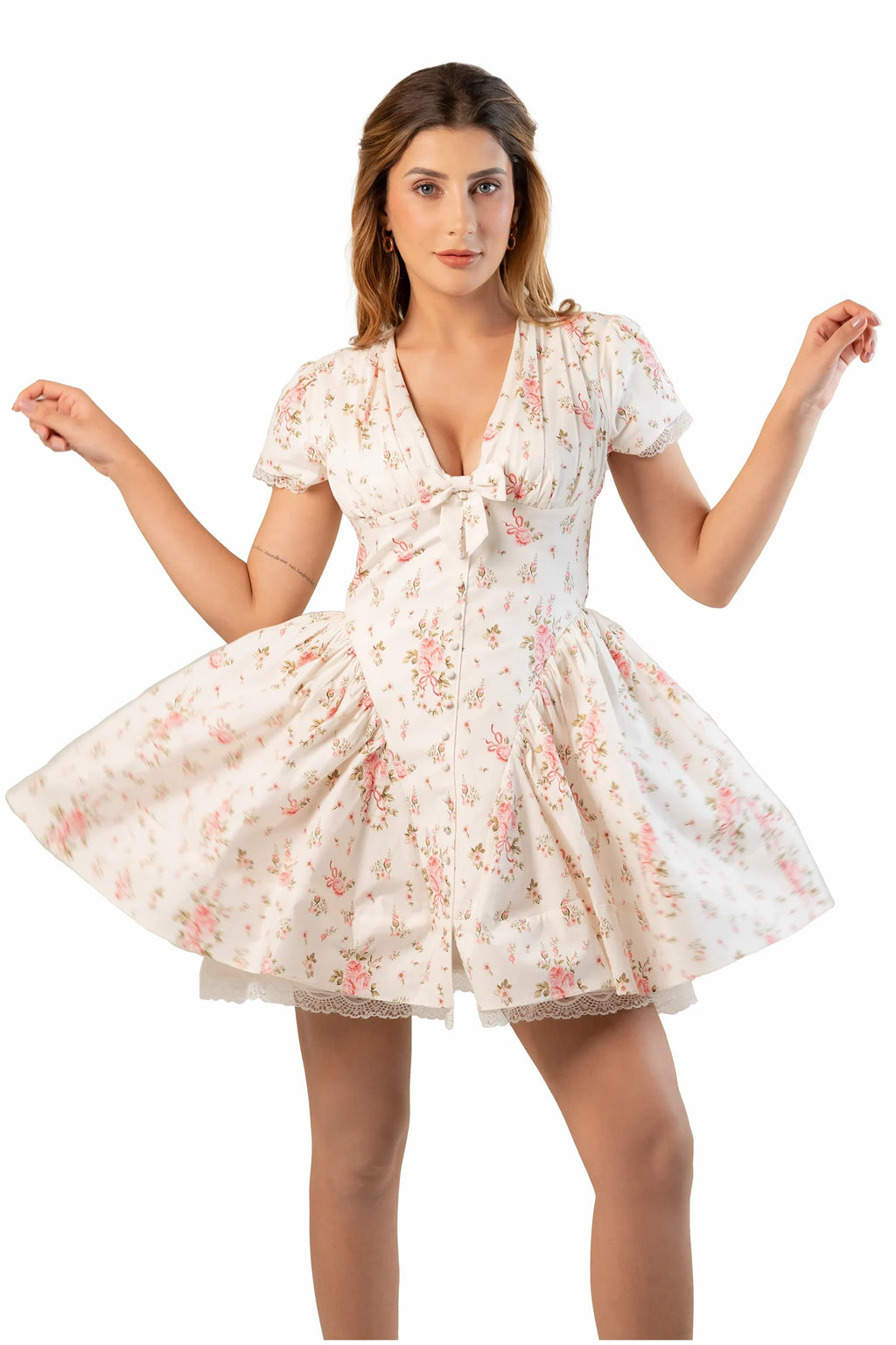 Cream floral mini dress with V-neck and short sleeves as model holds skirt to show flare.