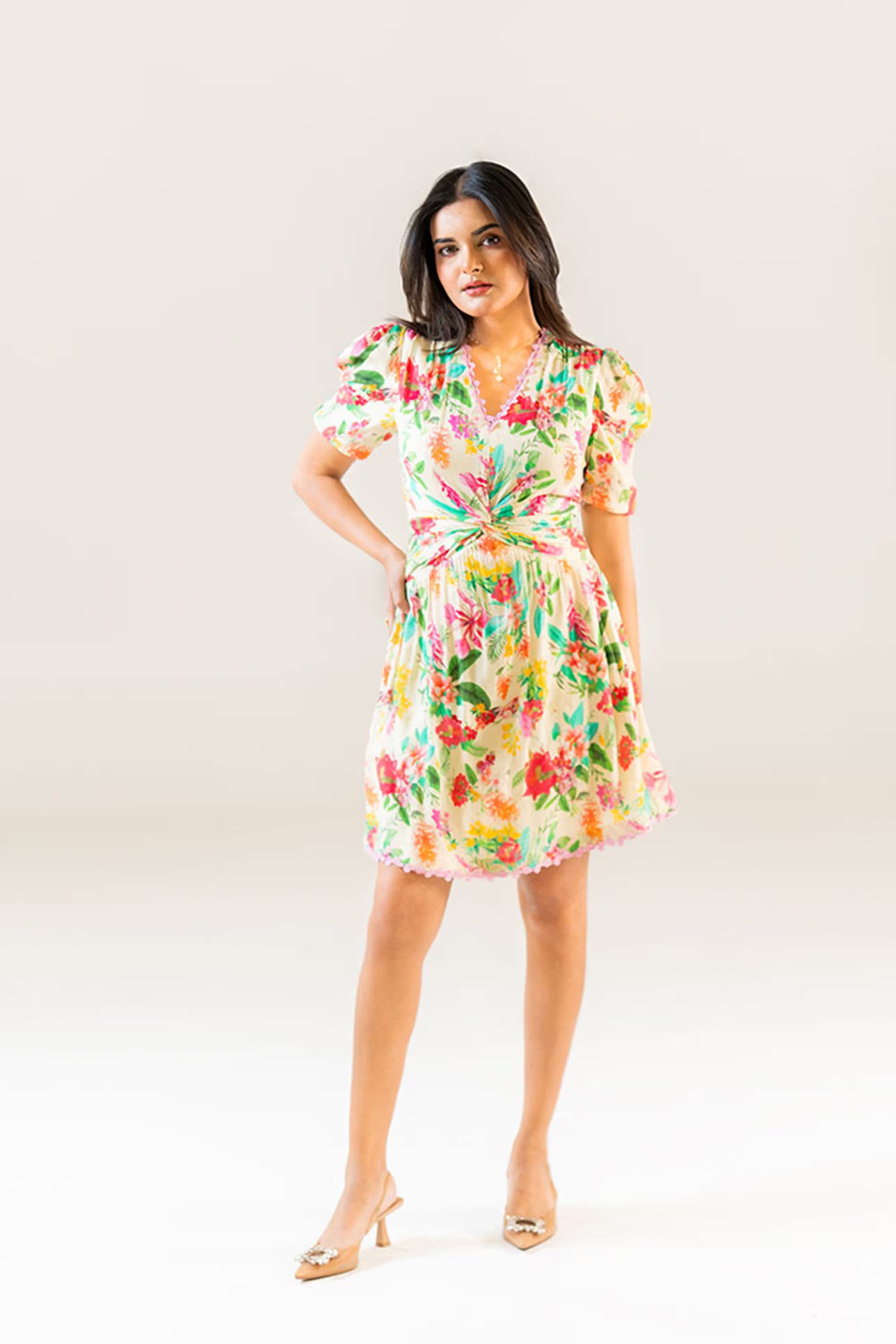 Front view of cream floral puff sleeve short dress with twist-front waist and lace trim