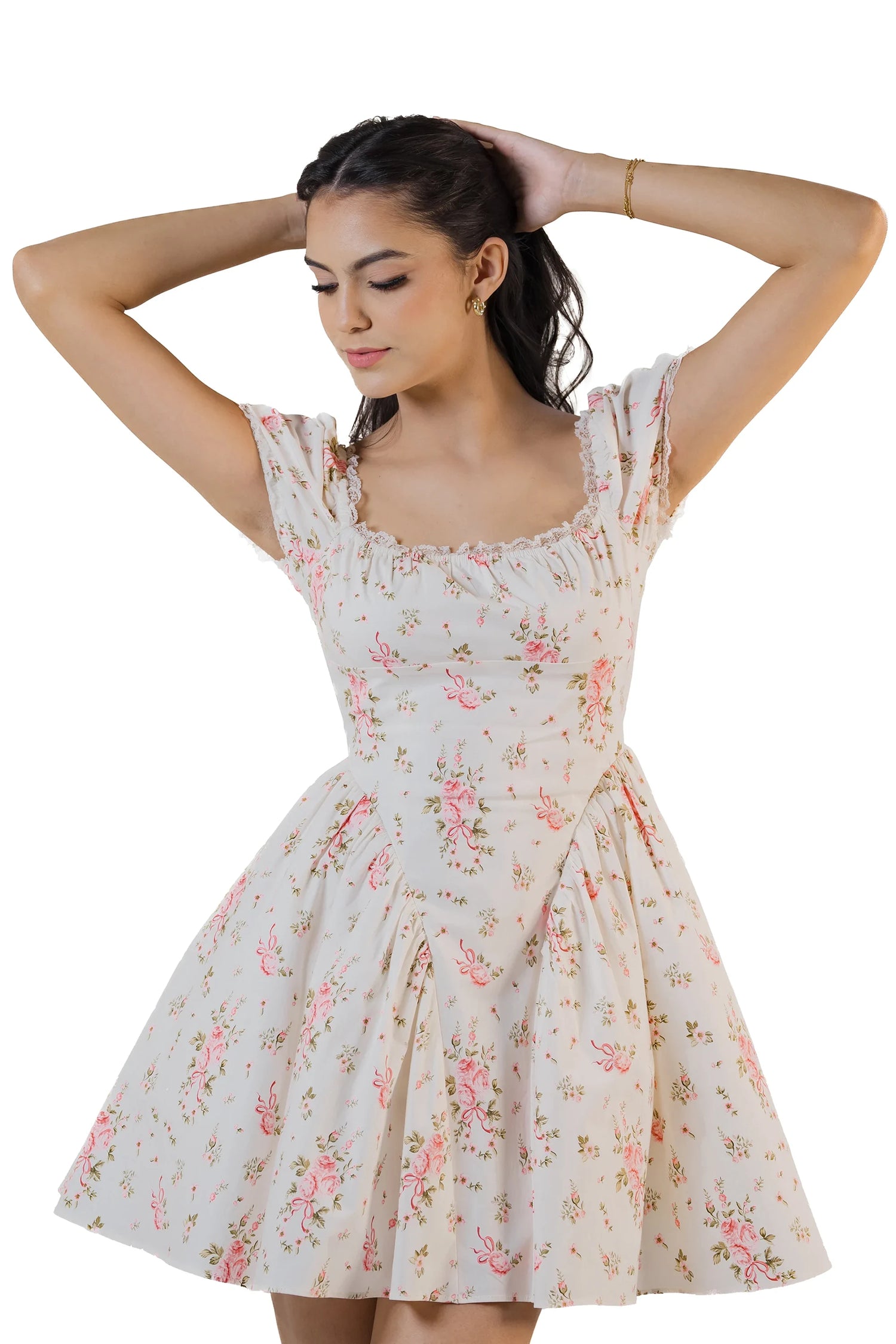 Cream white floral mini dress with square neckline and puff sleeves, arms raised behind head revealing the back.