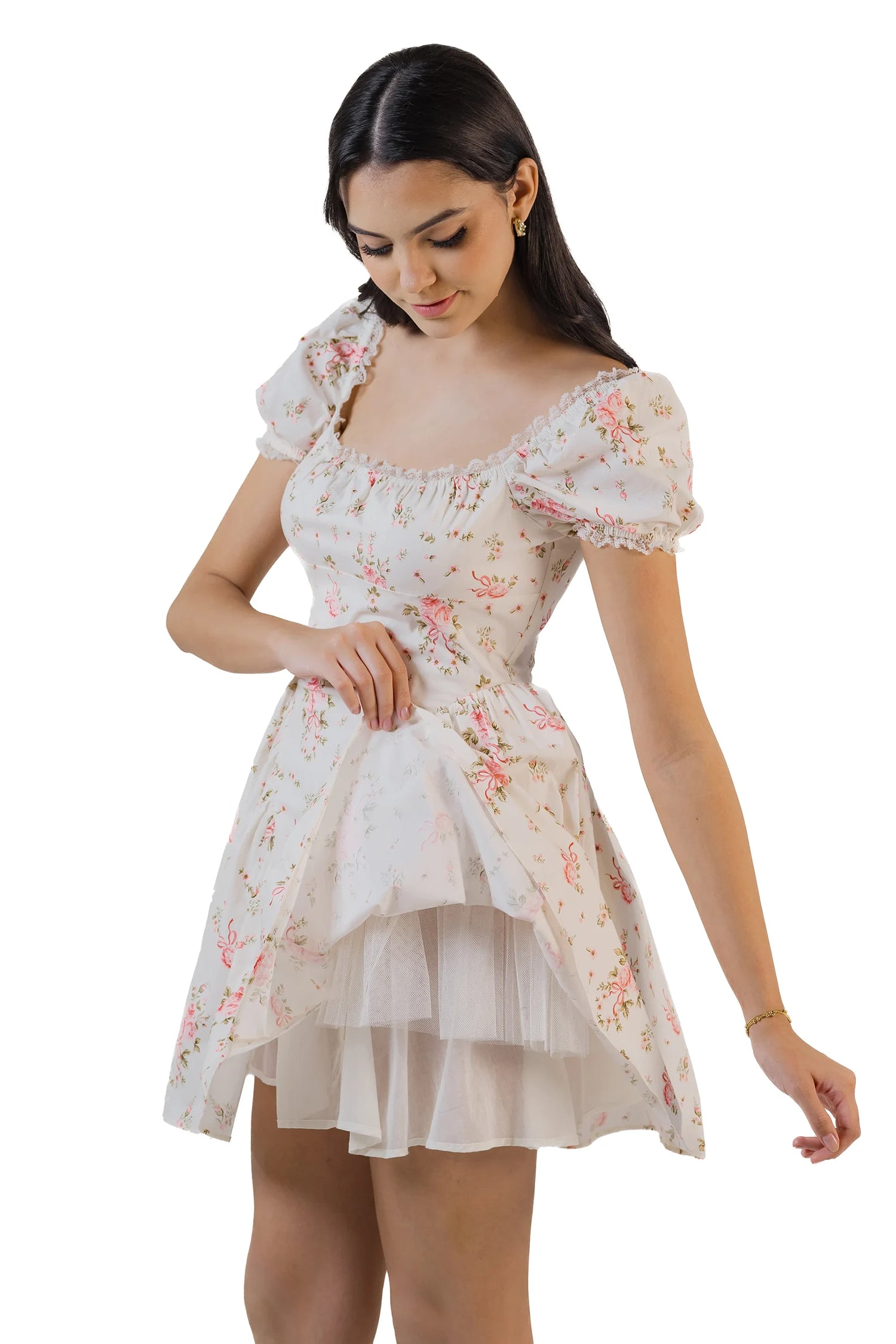 Angled view of cream white ruffle-tiered halter mini dress as model twirls, showing ruffled skirt.