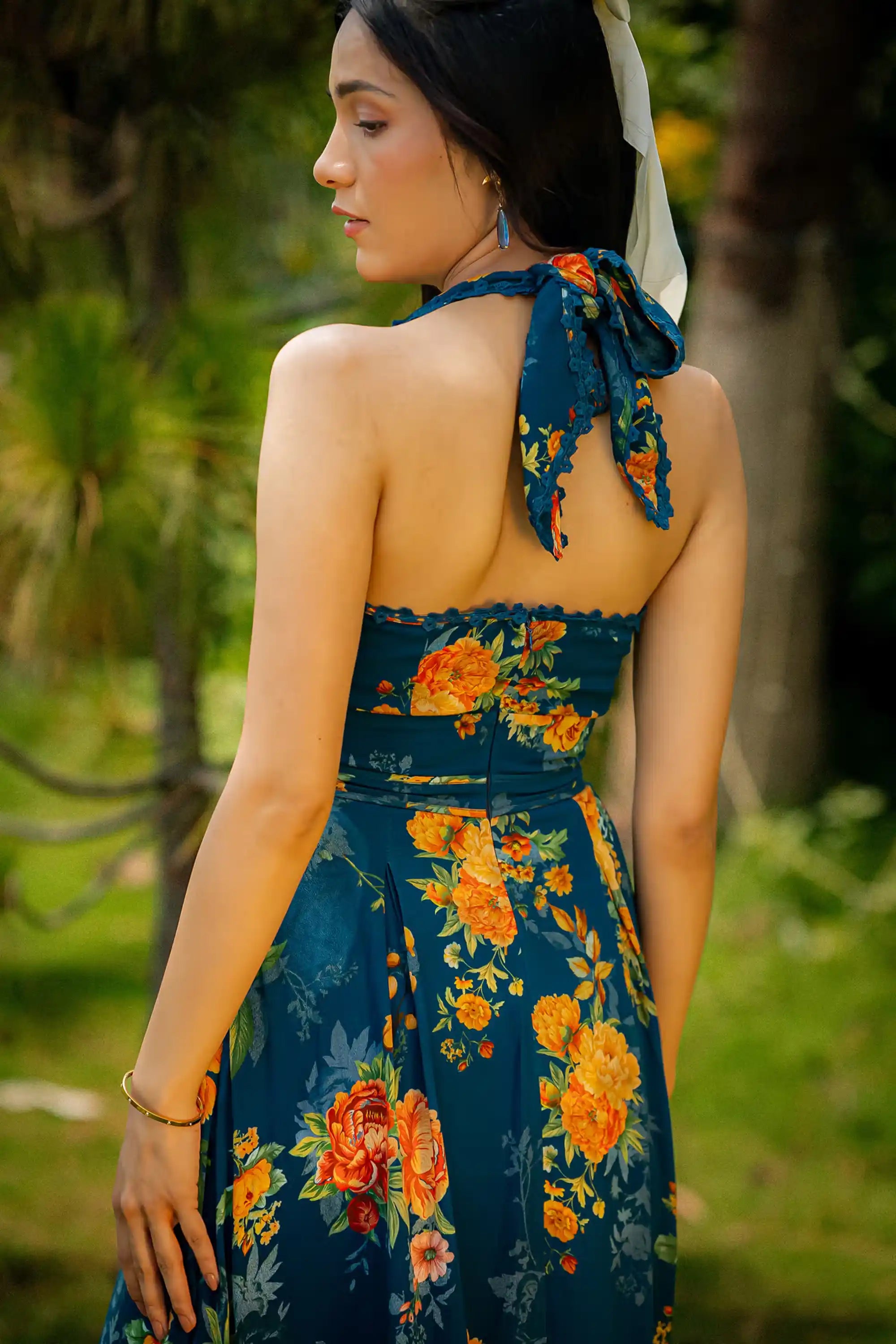 Back view of dark teal halter neck maxi dress with yellow floral design