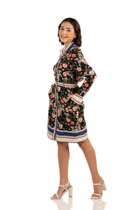 Side view of floral belted shirt dress with long sleeves, multicolor floral print, and striped trim hem.