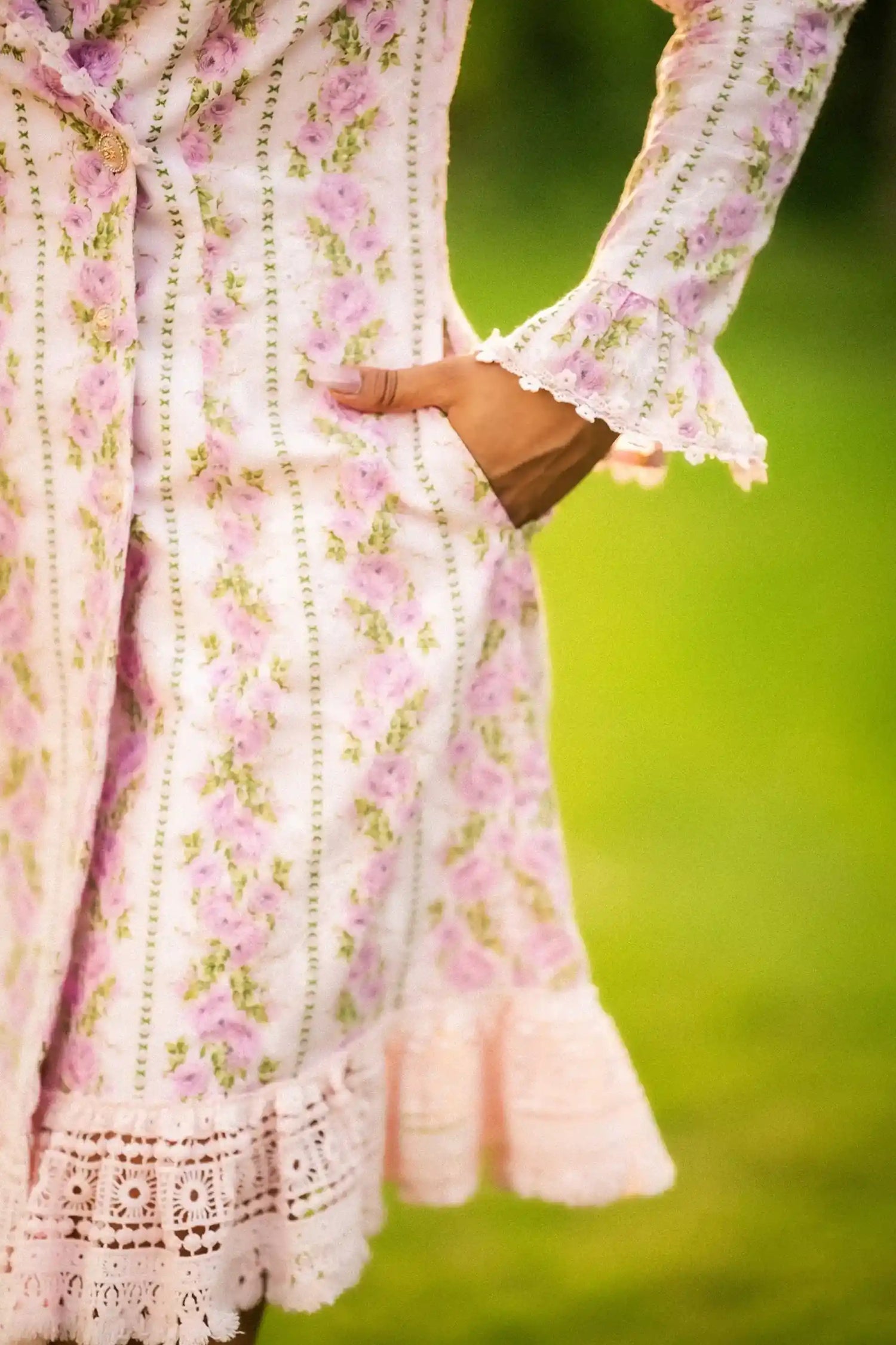 Button close-up on pink floral white lace trim mini dress