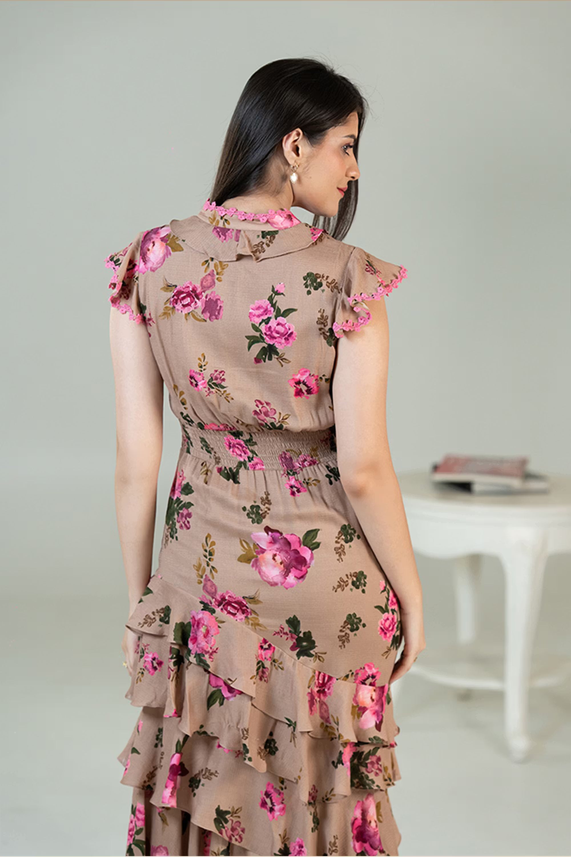 Back view of beige floral midi dress with ruffle layers and pink rose motifs