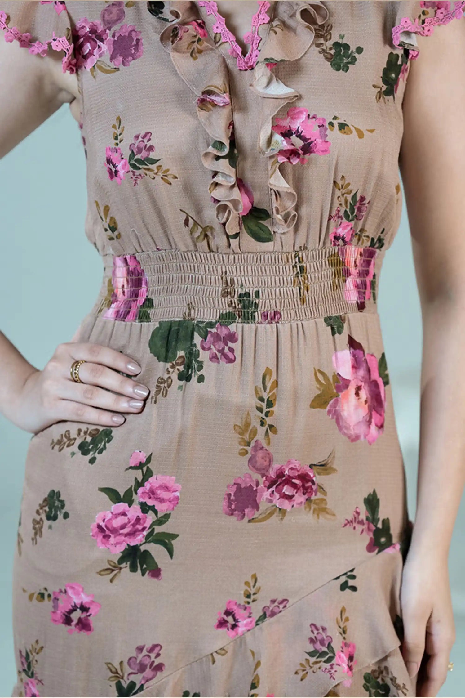 Waist detail of beige floral ruffle midi dress with pink rose print