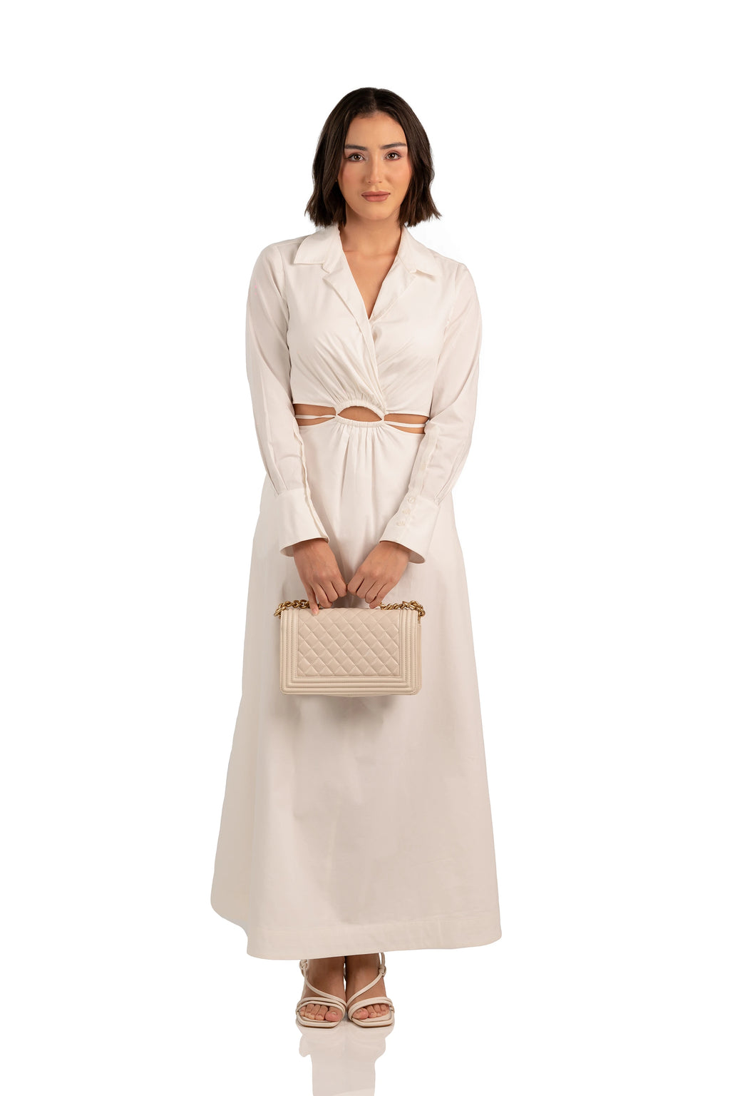 Women wearing front view of ivory maxi dress with collared neckline, cutout waist, and A-line skirt.