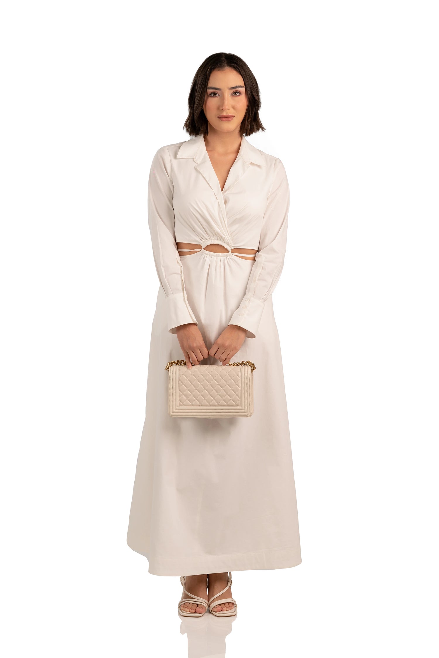 Women wearing front view of ivory maxi dress with collared neckline, cutout waist, and A-line skirt.