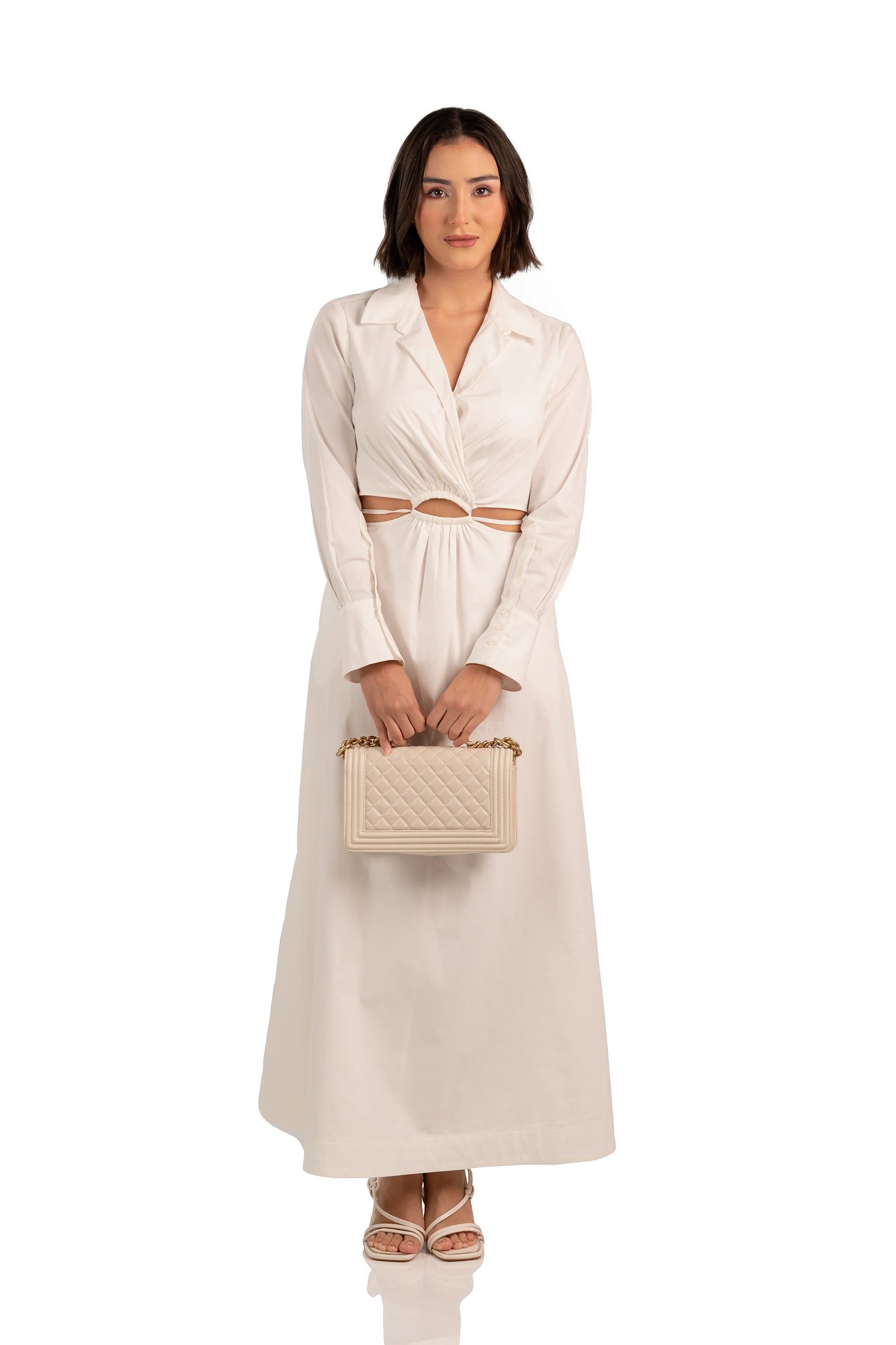 Women wearing front view of ivory maxi dress with collared neckline, cutout waist, and A-line skirt.